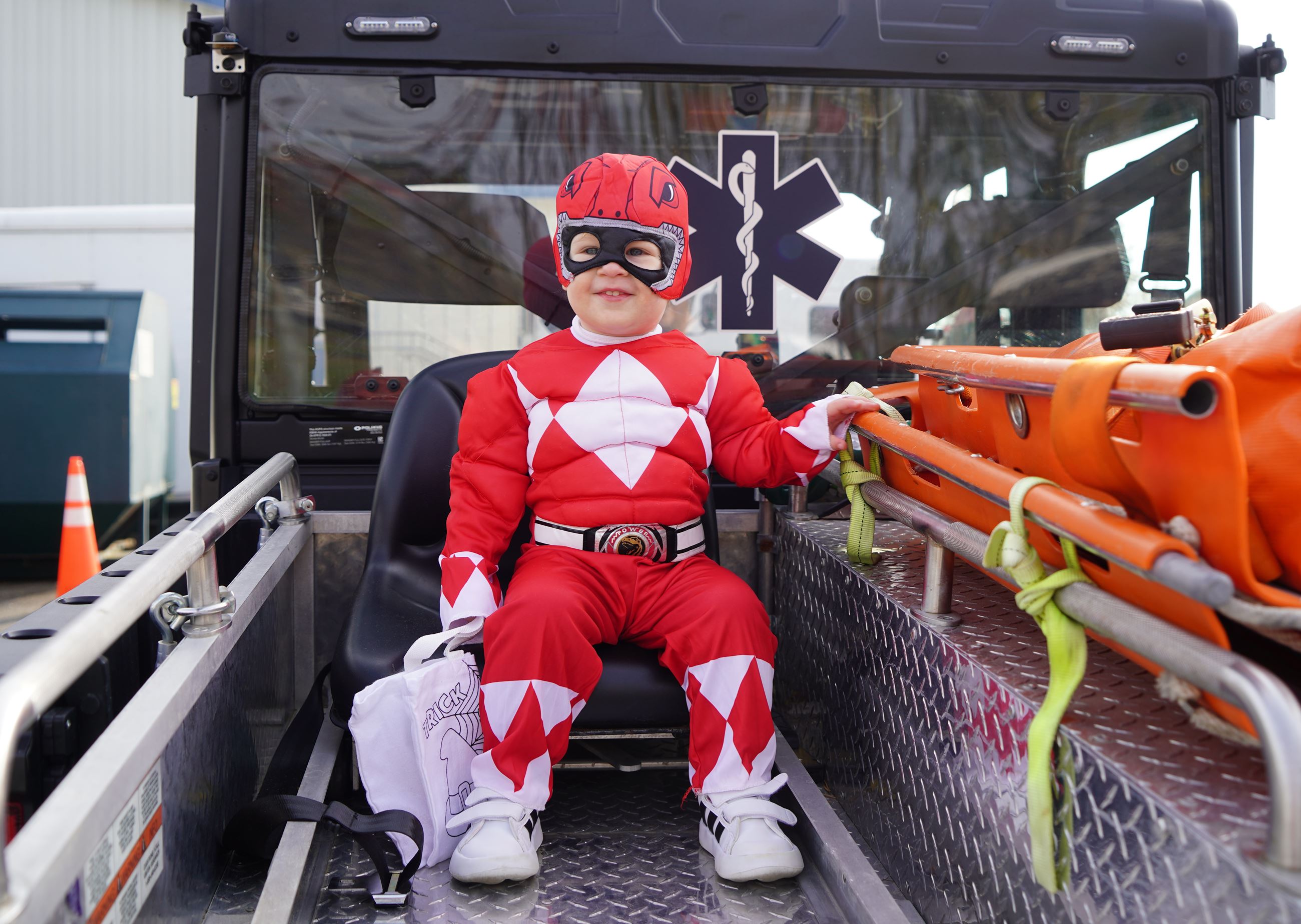 Photo of a boy in costume sitting on an EMS vehicle